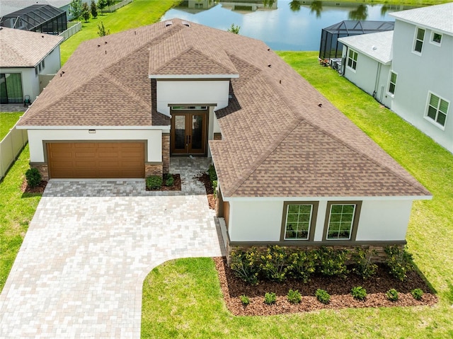 8749 Drummer Plank Dr, Wesley Chapel, FL 33545 - view of front of property featuring roof with shingles, an attached garage, french doors, driveway, and a water view