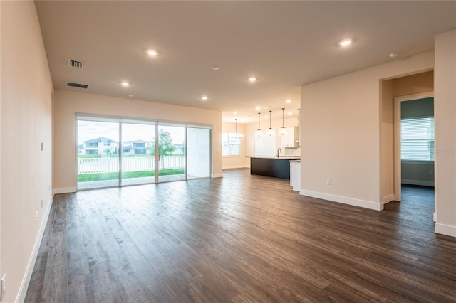 8749 Drummer Plank Dr, Wesley Chapel, FL 33545 - unfurnished living room featuring dark wood-type flooring and recessed lighting