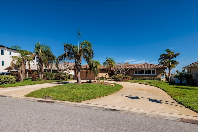 208 Bath Club Blvd N, North Redington Beach, FL 33708 - view of front of home featuring curved driveway, a front lawn, a tile roof, and stucco siding