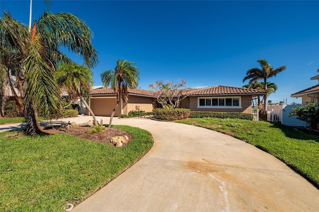 208 Bath Club Blvd N, North Redington Beach, FL 33708 - view of front of home with curved driveway, stucco siding, a front lawn, a tiled roof, and an attached garage