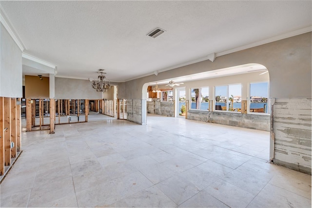208 Bath Club Blvd N, North Redington Beach, FL 33708 - unfurnished living room with a ceiling fan, a chandelier, crown molding, arched walkways, and a textured ceiling