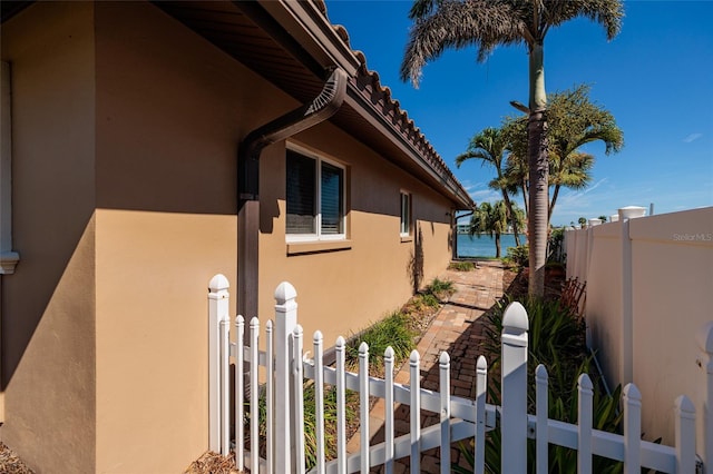 208 Bath Club Blvd N, North Redington Beach, FL 33708 - view of home's exterior with stucco siding, a fenced front yard, and a tiled roof