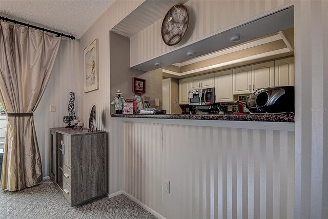 140 Dale Pl, Oldsmar, FL 34677 - kitchen with stainless steel microwave, light carpet, dark countertops, and a textured ceiling