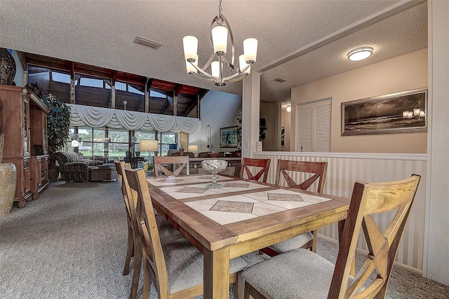 140 Dale Pl, Oldsmar, FL 34677 - dining room featuring carpet, a chandelier, and a textured ceiling