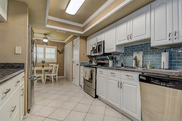 140 Dale Pl, Oldsmar, FL 34677 - kitchen featuring stainless steel appliances, ornamental molding, white cabinetry, light tile patterned flooring, and decorative backsplash