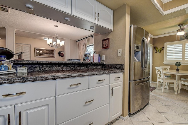 140 Dale Pl, Oldsmar, FL 34677 - kitchen with stainless steel fridge with ice dispenser, white cabinetry, light tile patterned flooring, healthy amount of natural light, and ornamental molding