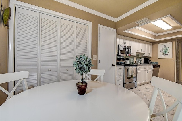 140 Dale Pl, Oldsmar, FL 34677 - kitchen with appliances with stainless steel finishes, crown molding, white cabinets, and light tile patterned floors