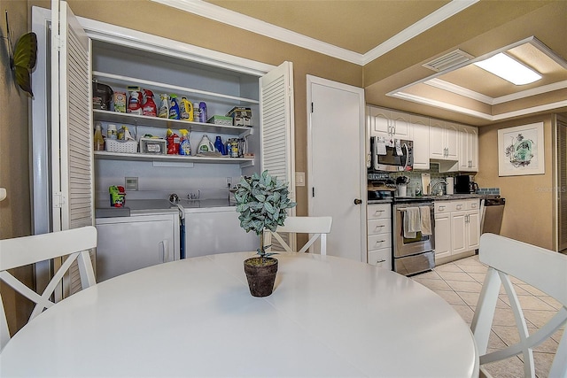 140 Dale Pl, Oldsmar, FL 34677 - dining area featuring crown molding, light tile patterned floors, and washing machine and dryer