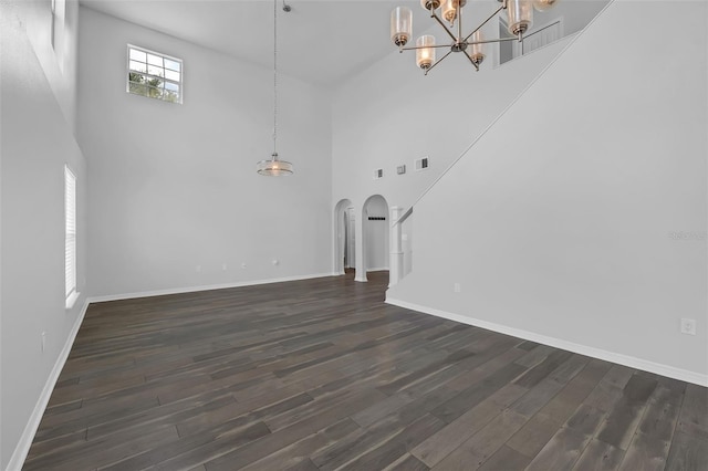 11130 Summer Star Dr, Riverview, FL 33579 - unfurnished living room with a towering ceiling, arched walkways, a chandelier, and dark wood-style flooring