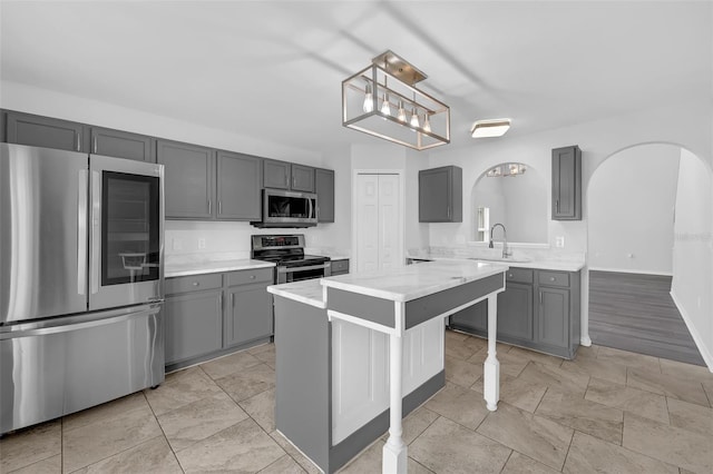 11130 Summer Star Dr, Riverview, FL 33579 - kitchen featuring stainless steel appliances, gray cabinetry, arched walkways, and light countertops