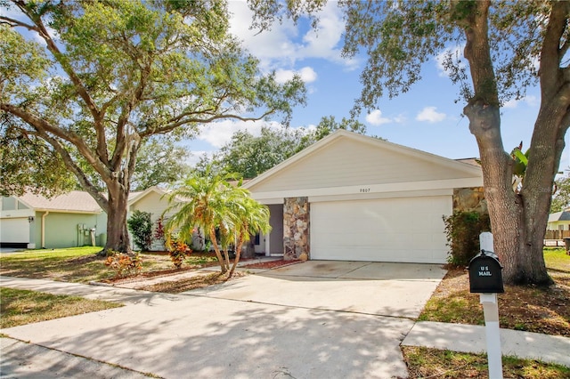 9807 Stephenson Dr, New Port Richey, FL 34655 - view of front of house with driveway, a garage, and stone siding