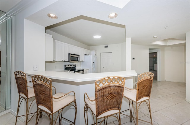 16600 Gulf Blvd Unit 437, North Redington Beach, FL 33708 - kitchen featuring appliances with stainless steel finishes, a breakfast bar, light countertops, a skylight, and recessed lighting