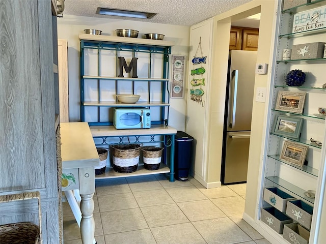 4712 Marine Pkwy Unit 203, New Port Richey, FL 34652 - kitchen with freestanding refrigerator, a textured ceiling, and light tile patterned floors