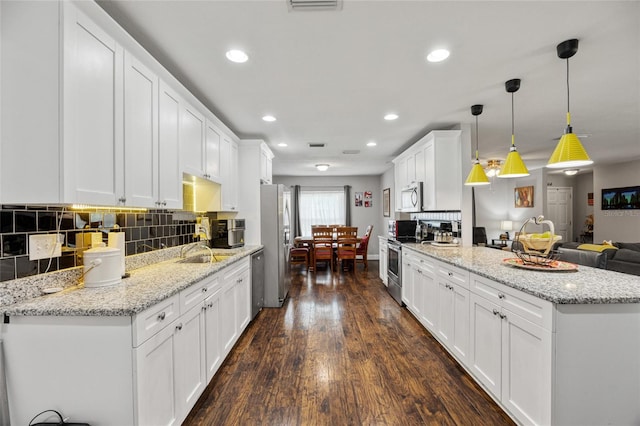 602 Hillpoint Way, Brandon, FL 33510 - kitchen with appliances with stainless steel finishes, a peninsula, recessed lighting, dark wood-style floors, and white cabinets