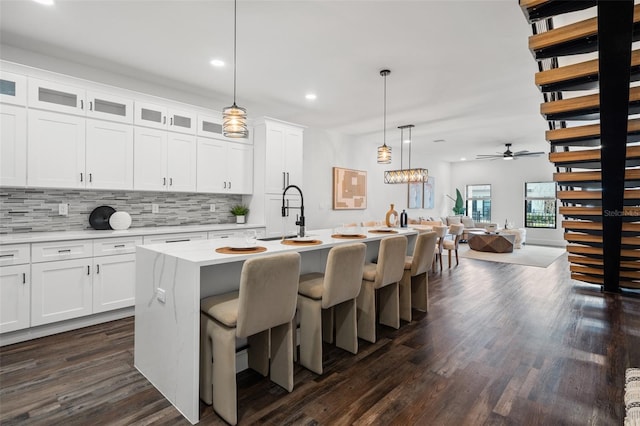 6206 64th Way N, Pinellas Park, FL 33781 - kitchen with a ceiling fan, dark wood-style flooring, decorative backsplash, light countertops, and open floor plan
