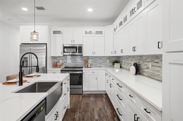 6206 64th Way N, Pinellas Park, FL 33781 - kitchen with appliances with stainless steel finishes, dark wood-style floors, decorative light fixtures, tasteful backsplash, and white cabinetry