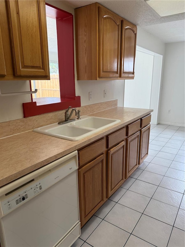 8801 Orange Blossom Dr, Seminole, FL 33772 - kitchen with dishwasher, brown cabinetry, light countertops, light tile patterned floors, and a textured ceiling
