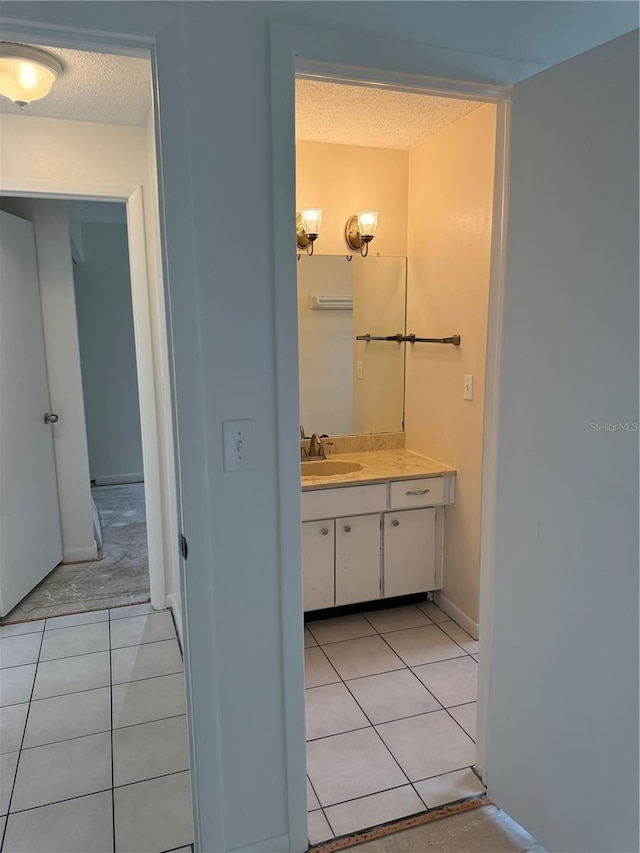 8801 Orange Blossom Dr, Seminole, FL 33772 - bathroom featuring tile patterned floors, a textured ceiling, and vanity