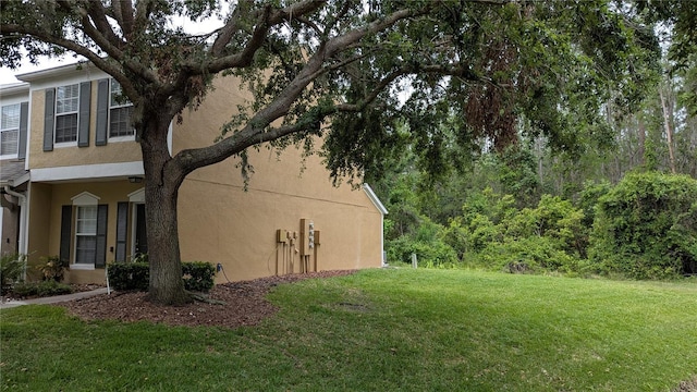 1247 Kennewick Ct, Wesley Chapel, FL 33543 - view of side of home with stucco siding and a yard