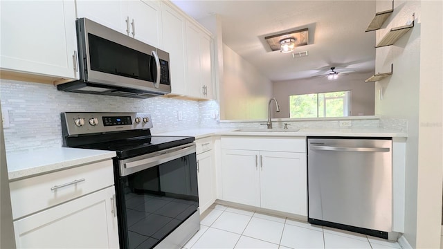 1247 Kennewick Ct, Wesley Chapel, FL 33543 - kitchen with stainless steel appliances, a ceiling fan, light countertops, light tile patterned floors, and decorative backsplash