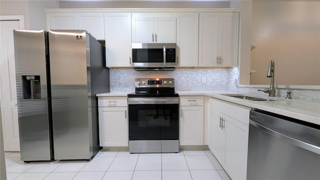 1247 Kennewick Ct, Wesley Chapel, FL 33543 - kitchen featuring stainless steel appliances, decorative backsplash, white cabinetry, and light tile patterned flooring