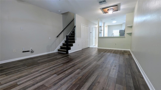 1247 Kennewick Ct, Wesley Chapel, FL 33543 - unfurnished living room featuring stairs and dark wood-style floors