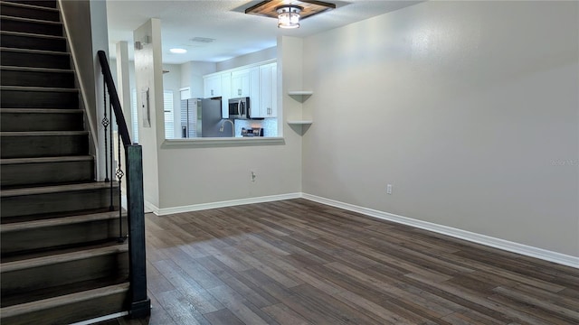 1247 Kennewick Ct, Wesley Chapel, FL 33543 - unfurnished living room featuring stairway and dark wood-style flooring