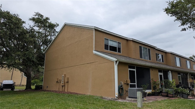 1247 Kennewick Ct, Wesley Chapel, FL 33543 - view of property exterior featuring stucco siding and a lawn