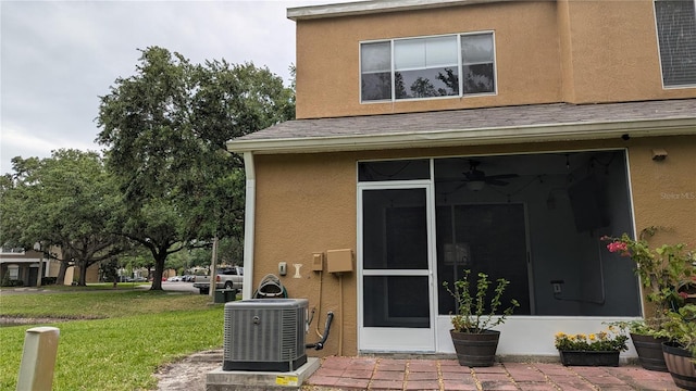 1247 Kennewick Ct, Wesley Chapel, FL 33543 - doorway to property featuring a yard, stucco siding, and a shingled roof