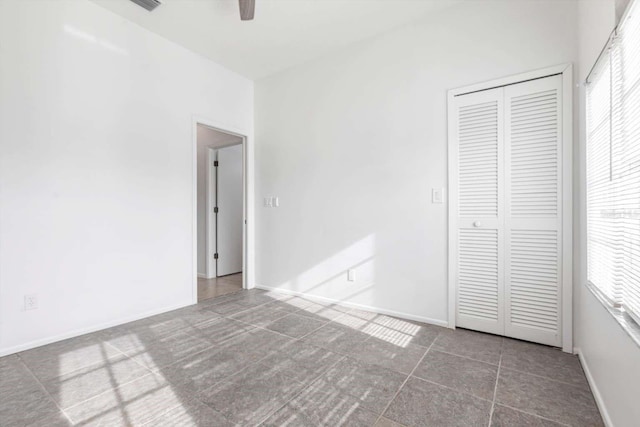 5017 46th St W, Bradenton, FL 34210 - unfurnished bedroom with multiple windows, a closet, tile patterned flooring, and ceiling fan