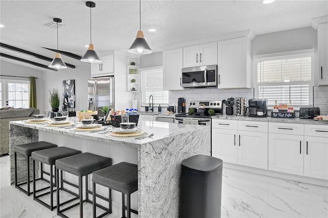 8010 W Hiawatha St, Tampa, FL 33615 - kitchen featuring appliances with stainless steel finishes, decorative backsplash, light marble finish flooring, recessed lighting, and white cabinetry