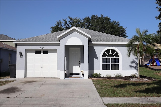 1006 Harvest Moon Dr, Seffner, FL 33584 - ranch-style house with concrete driveway, an attached garage, roof with shingles, stucco siding, and a playground