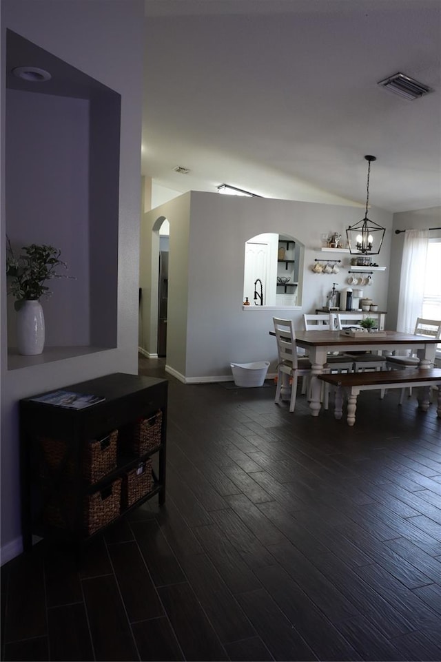 1006 Harvest Moon Dr, Seffner, FL 33584 - dining area featuring arched walkways, dark wood-style floors, and a chandelier
