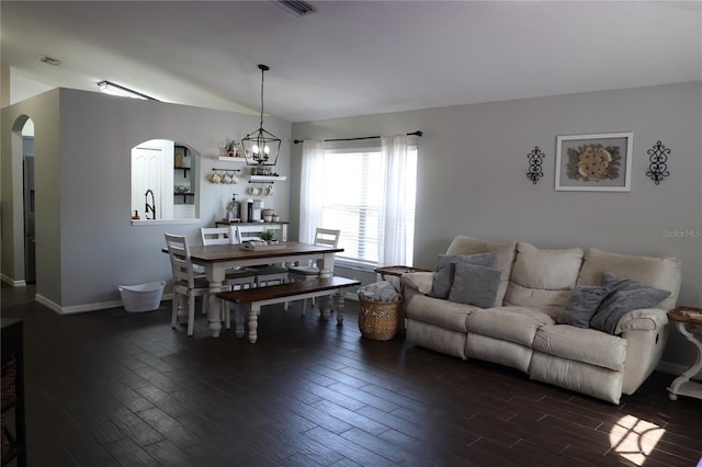 1006 Harvest Moon Dr, Seffner, FL 33584 - living area with arched walkways, dark wood-style floors, a chandelier, and lofted ceiling