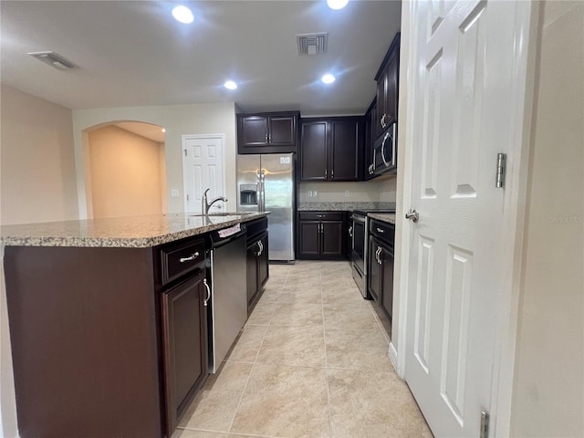 3724 Crofton Ct, Fort Myers, FL 33916 - kitchen with appliances with stainless steel finishes, arched walkways, an island with sink, light tile patterned flooring, and recessed lighting