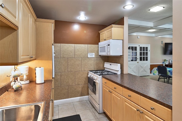 4215 E Bay Dr Unit 1706A, Clearwater, FL 33764 - kitchen with white appliances, dark countertops, light tile patterned floors, light brown cabinets, and tile walls