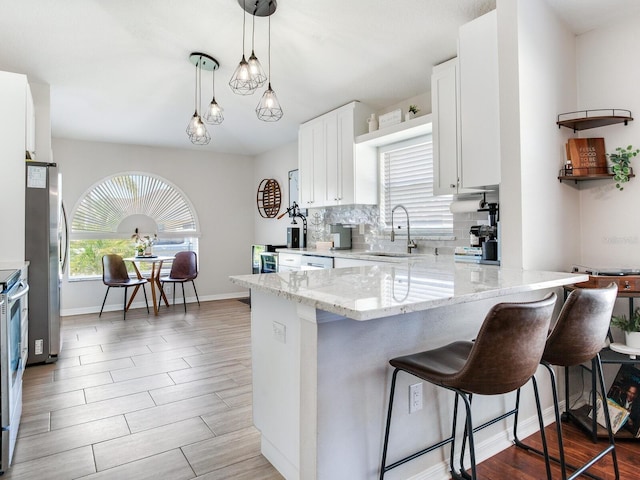 24811 Gun Smoke Dr, Land O Lakes, FL 34639 - kitchen with a breakfast bar area, white cabinets, light stone countertops, and tasteful backsplash