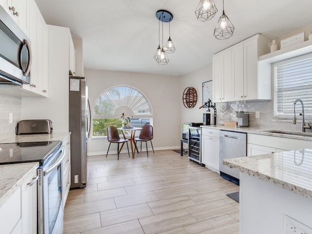 24811 Gun Smoke Dr, Land O Lakes, FL 34639 - kitchen with stainless steel appliances, tasteful backsplash, and white cabinets