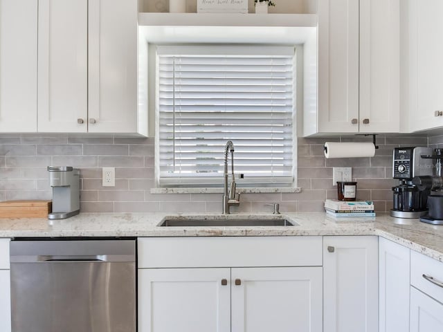 24811 Gun Smoke Dr, Land O Lakes, FL 34639 - kitchen with stainless steel dishwasher, white cabinetry, tasteful backsplash, and light stone counters