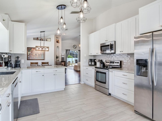 24811 Gun Smoke Dr, Land O Lakes, FL 34639 - kitchen featuring appliances with stainless steel finishes, decorative backsplash, white cabinets, pendant lighting, and light stone countertops
