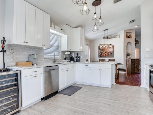 24811 Gun Smoke Dr, Land O Lakes, FL 34639 - kitchen featuring stainless steel dishwasher, beverage cooler, tasteful backsplash, white cabinetry, and a peninsula