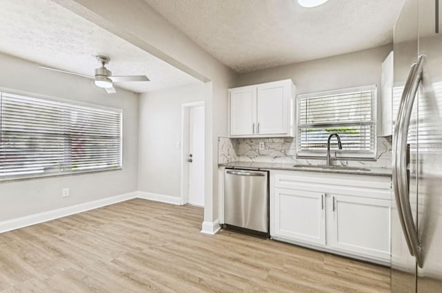 10215 N 23rd St, Tampa, FL 33612 - kitchen with appliances with stainless steel finishes, a textured ceiling, white cabinets, light wood-type flooring, and ceiling fan