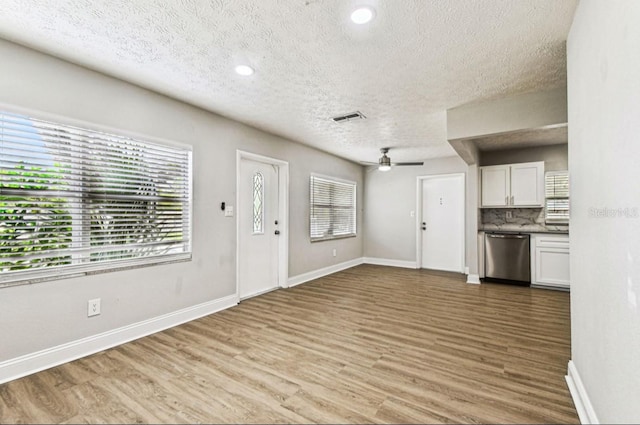 10215 N 23rd St, Tampa, FL 33612 - unfurnished living room featuring a textured ceiling, light wood-style flooring, a ceiling fan, and recessed lighting