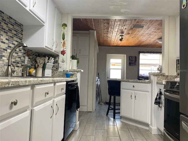 4219 Gray Squirrel Ln, New Port Richey, FL 34653 - kitchen featuring wood ceiling, decorative backsplash, oven, white cabinets, and black dishwasher