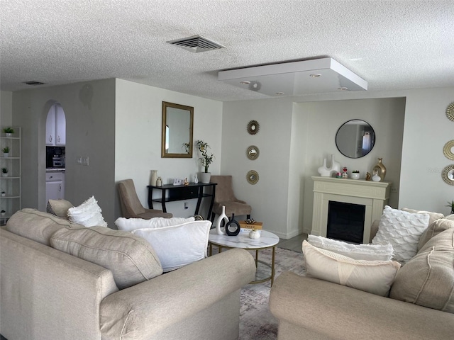 4219 Gray Squirrel Ln, New Port Richey, FL 34653 - living room with arched walkways, a fireplace, and a textured ceiling