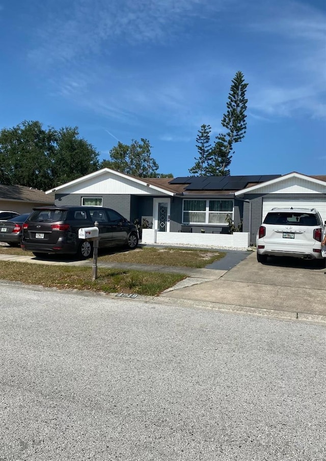 4219 Gray Squirrel Ln, New Port Richey, FL 34653 - ranch-style home featuring driveway, solar panels, and a garage