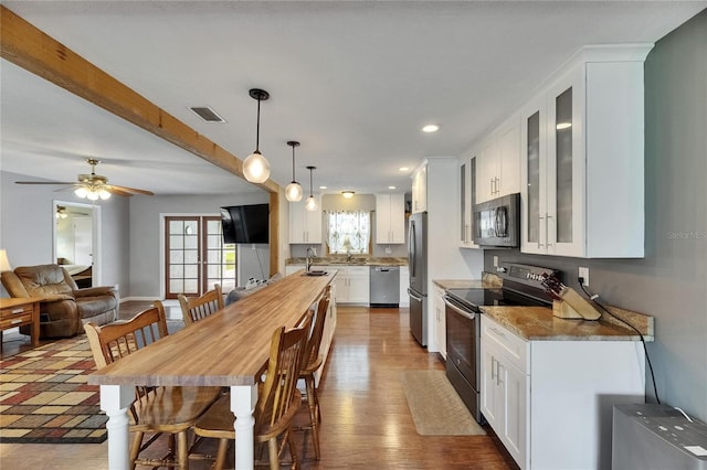2914 Forest Cir, Seffner, FL 33584 - kitchen with appliances with stainless steel finishes, glass insert cabinets, white cabinets, hanging light fixtures, and dark wood-style floors