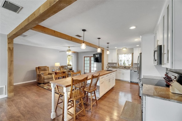 2914 Forest Cir, Seffner, FL 33584 - kitchen with appliances with stainless steel finishes, open floor plan, light wood-style floors, white cabinetry, and recessed lighting