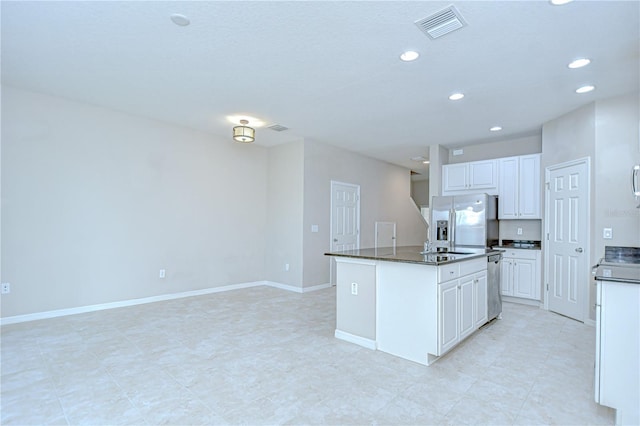 7077 Woodchase Glen Dr, Riverview, FL 33578 - kitchen with stainless steel appliances, dark countertops, recessed lighting, a center island with sink, and white cabinetry