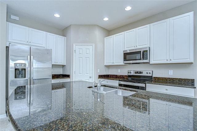 7077 Woodchase Glen Dr, Riverview, FL 33578 - kitchen featuring appliances with stainless steel finishes, white cabinets, dark stone counters, and recessed lighting